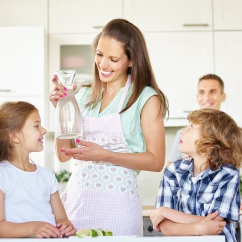 Mom providing cleaner, better-tasting water for her children with a whole house water filtration system