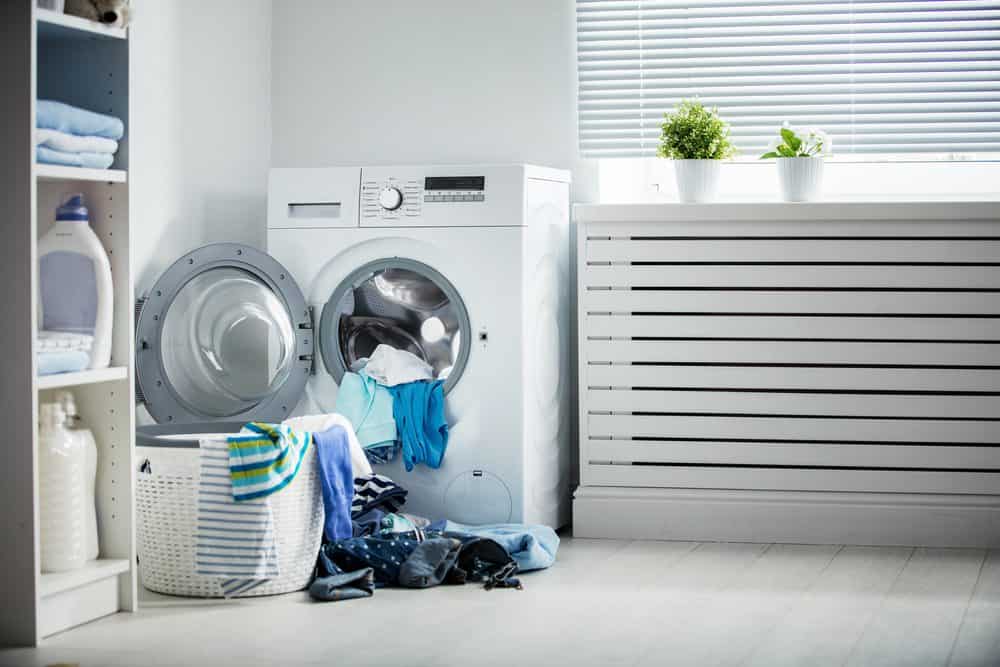 Clean soft clothes halfway unloaded from washing machine on water softener system